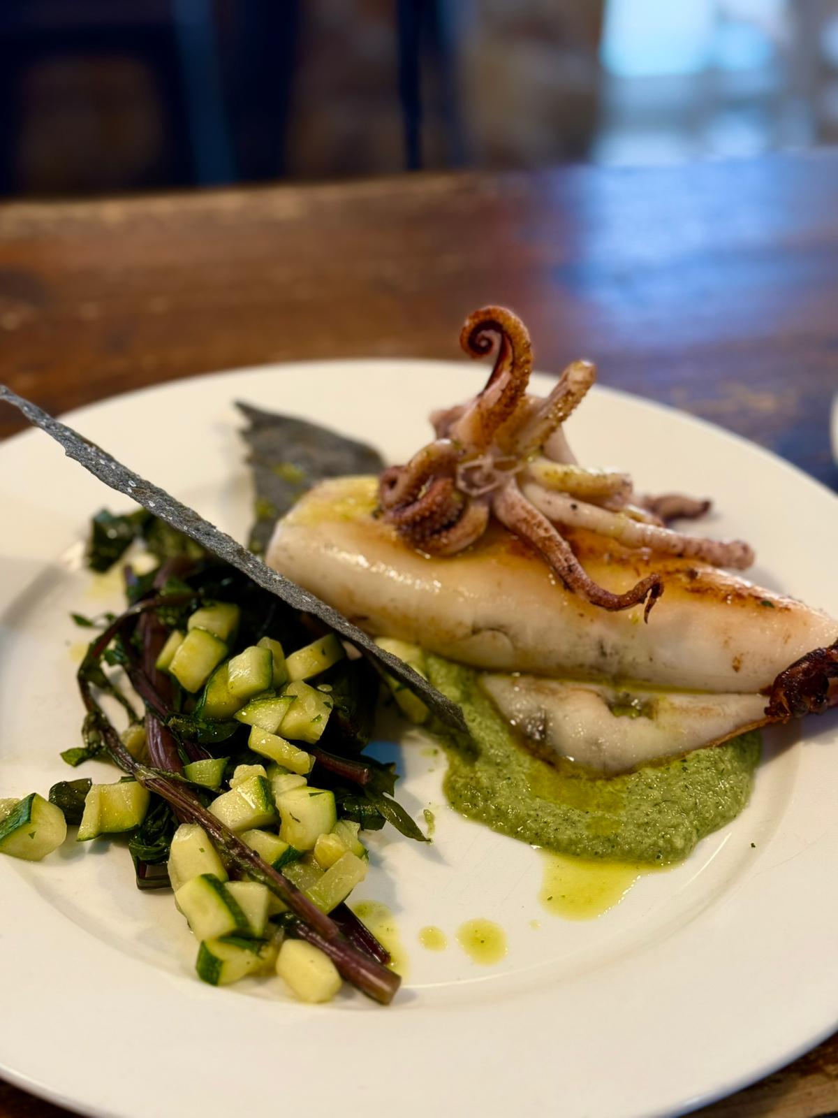 Piatto di calamari grigliati con verdure e salsa verde